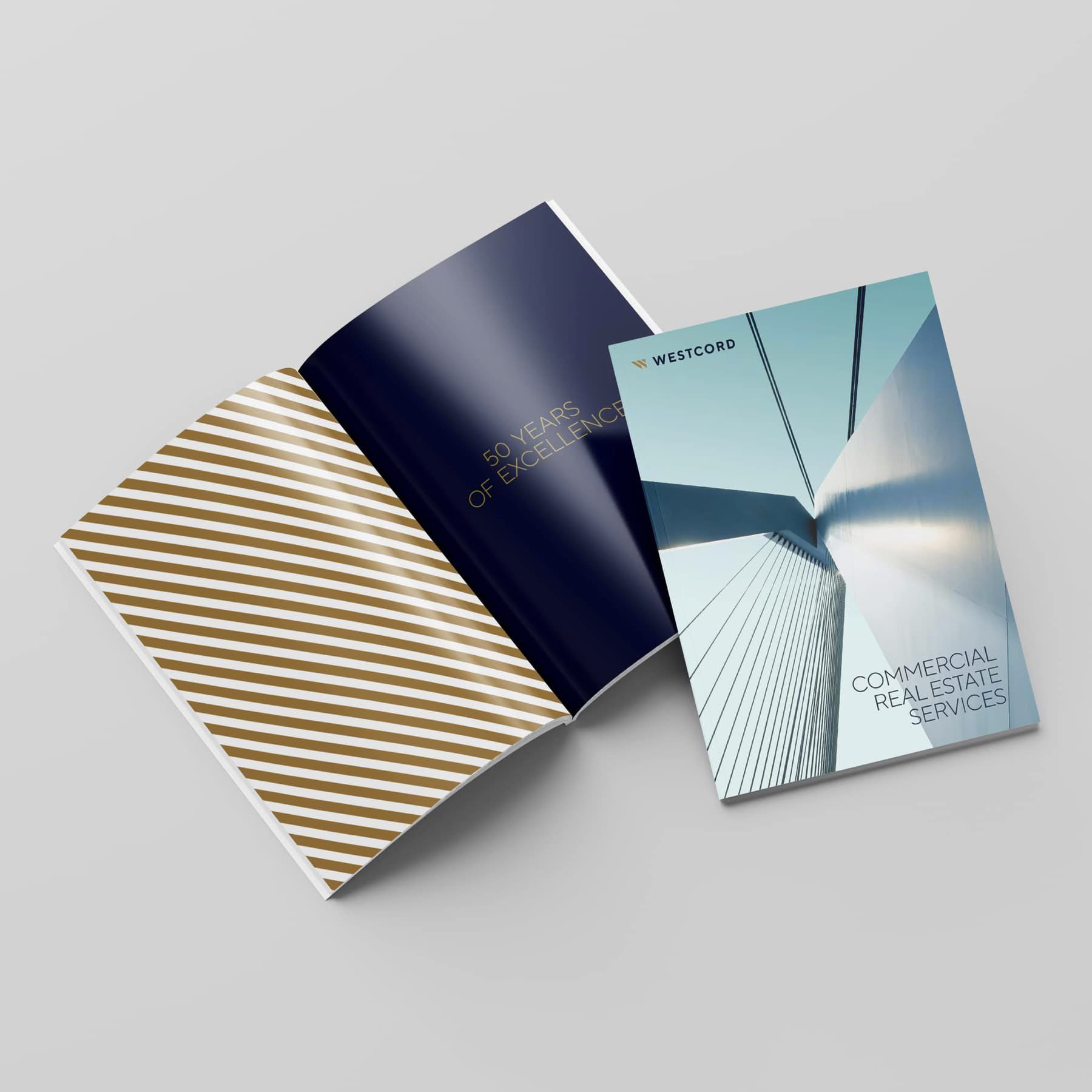 Two Westcord brochure covers, one navy with a '50 Years of Excellence' gold foil spread and one titled 'Commercial Real Estate Services' over an architectural photograph.